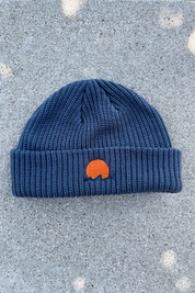 Classic cuffed knit fisherman beanie featuring embroidered Rooted Swim sunset logo in a blue gray color. high quality knit beanie