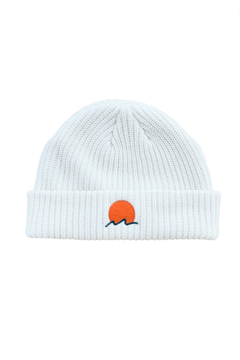 Classic cuffed knit fisherman beanie featuring embroidered Rooted Swim sunset logo in a shell soft white color. high quality knit beanie