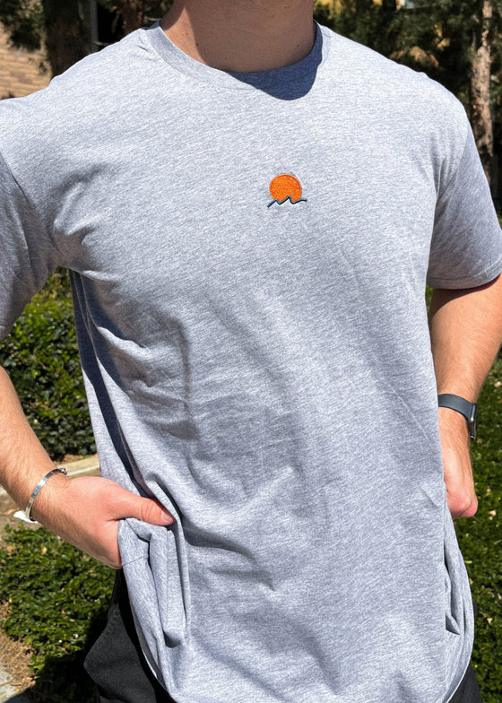 Rooted Swim Sunset Embroidered Tee Shirt in Heather Gray. Includes red sun and dark green wave design.