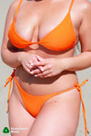 Rooted Swim skimpy bright poppy orange bikini bottoms, best for tanning
